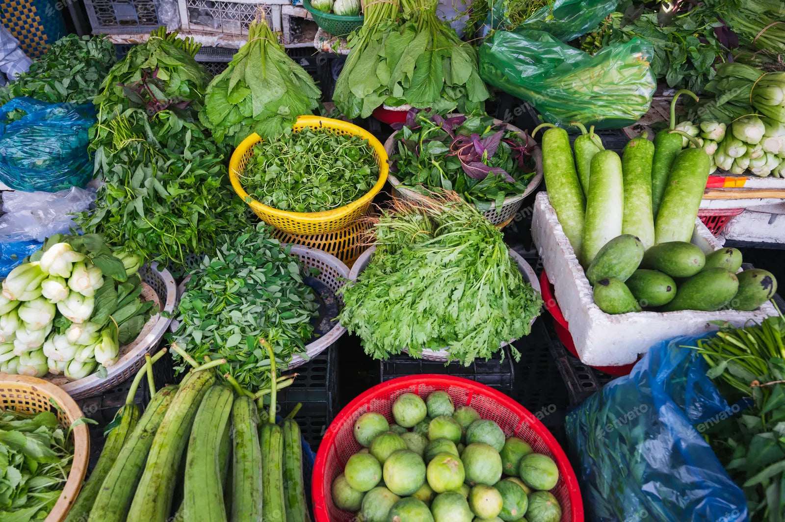 Various vegetables and herbs on the market in wicker baskets.