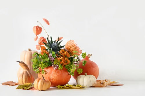 Autumn bouquet with different orange and yellow flowers in pumpkin for Thanksgiving Day.