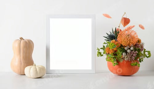 Autumn mockup with flowers bouquet in pumpkin, decor elements and white frame.