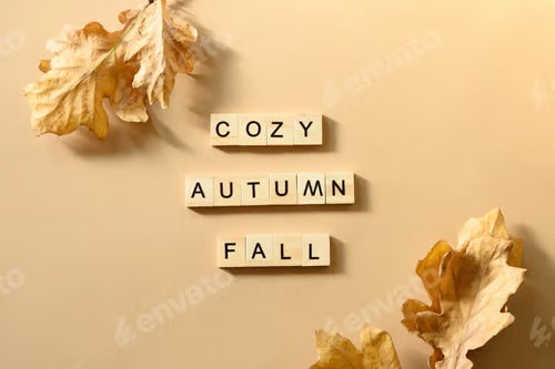 Golden dry oak leaves and wooden blocks with letters and text - Fall, Cozy, Autumn. View from above.