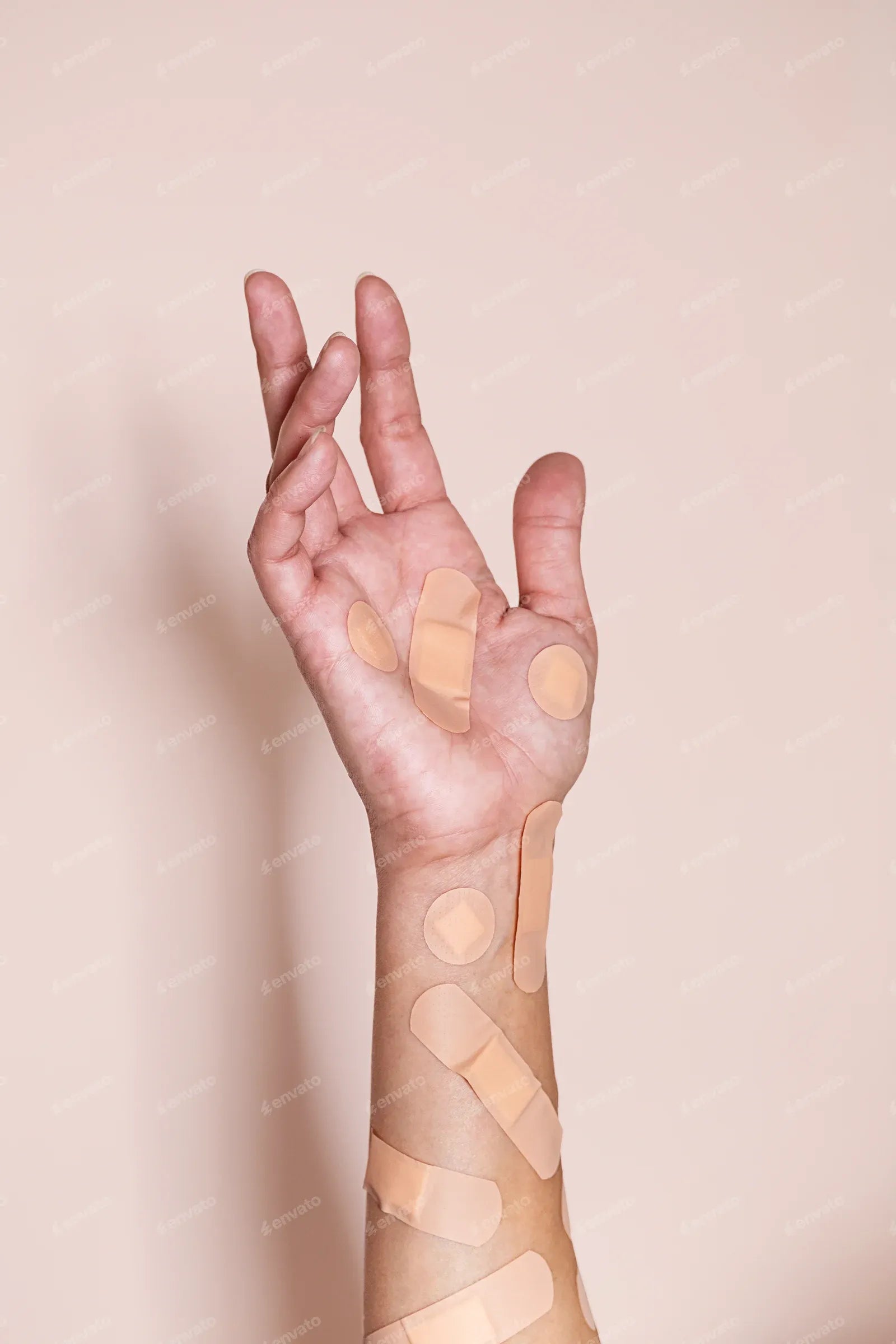 Human arm covered with various adhesive bandages.