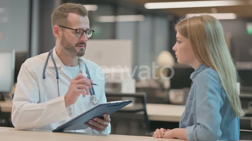 Positive Middle Aged Male Doctor Talking to Female Patient